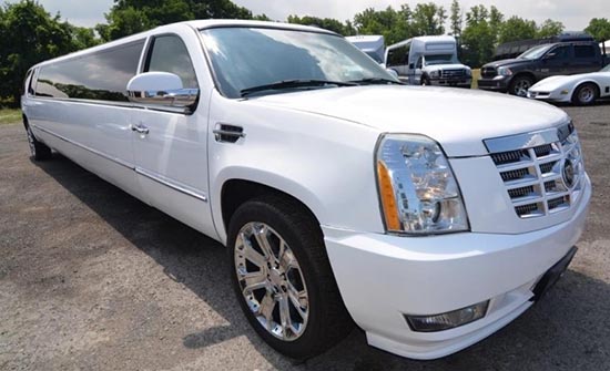 A white limo is parked in the parking lot.