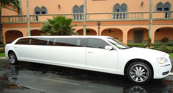 A white limo parked in front of a building.