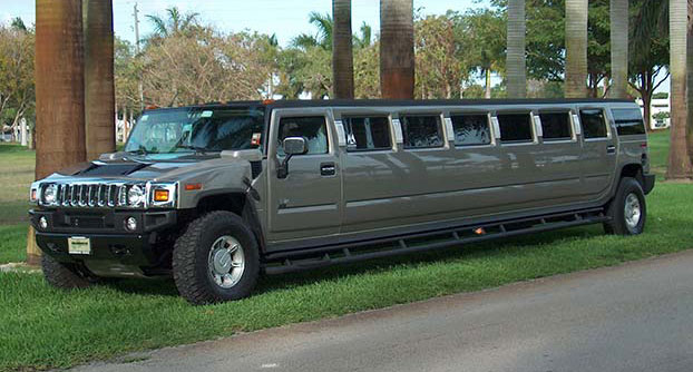 A long stretch limo parked on the side of a road.