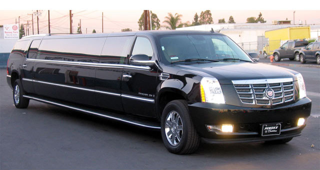 A black limo is driving down the street.