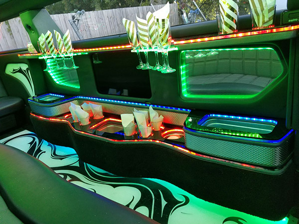 A green and white lit up interior of a limo.