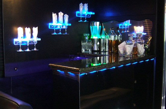 A bar with blue lights and bottles on the table