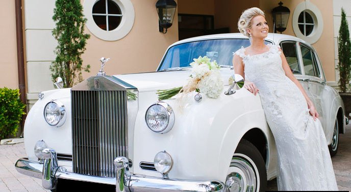 A woman standing next to a white car.